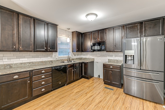 kitchen featuring sink, black appliances, light hardwood / wood-style flooring, and dark brown cabinets