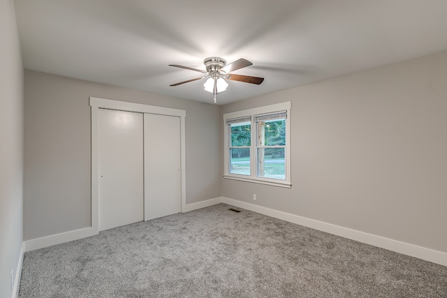 unfurnished bedroom with a closet, ceiling fan, and light carpet