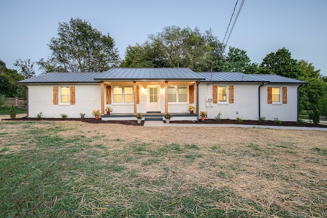 ranch-style house featuring a front yard and covered porch