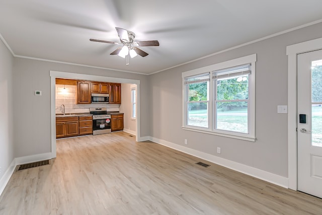 unfurnished living room with light wood-type flooring, a wealth of natural light, and ceiling fan