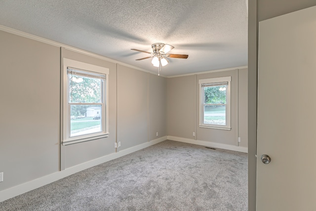 unfurnished room with ceiling fan, a textured ceiling, crown molding, and light colored carpet