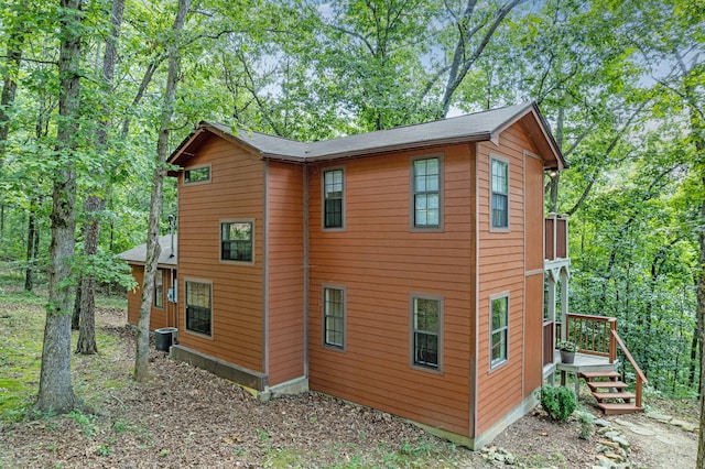 view of side of property with a deck and central AC