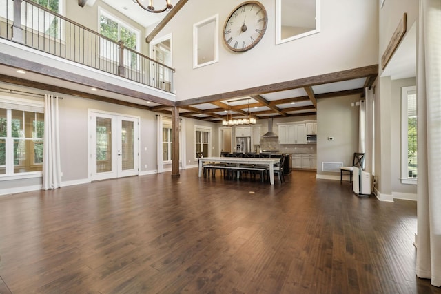 unfurnished dining area with french doors, dark wood finished floors, visible vents, beamed ceiling, and baseboards