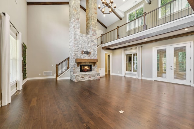 unfurnished living room featuring baseboards, a fireplace, visible vents, and dark wood finished floors