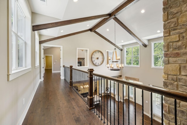 hall featuring vaulted ceiling with beams, a chandelier, dark wood-type flooring, an upstairs landing, and baseboards