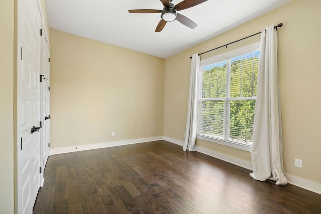 unfurnished room with dark wood-style floors, a wealth of natural light, and baseboards