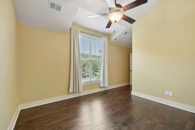 empty room with dark wood-type flooring, visible vents, baseboards, and a ceiling fan