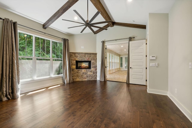 unfurnished living room with baseboards, ceiling fan, dark wood-type flooring, vaulted ceiling with beams, and a stone fireplace