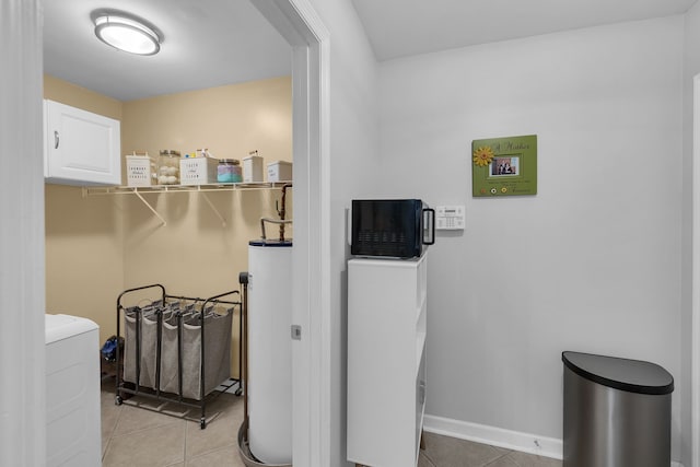 washroom with light tile patterned flooring, gas water heater, and washer / clothes dryer