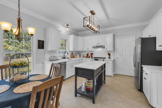 kitchen featuring backsplash, white cabinets, sink, and hanging light fixtures