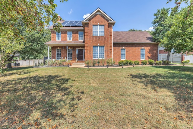 view of front of house featuring a front yard and solar panels