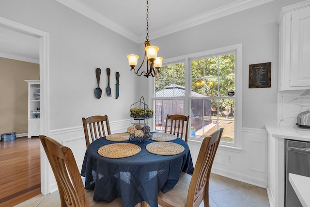 tiled dining area featuring a chandelier and ornamental molding