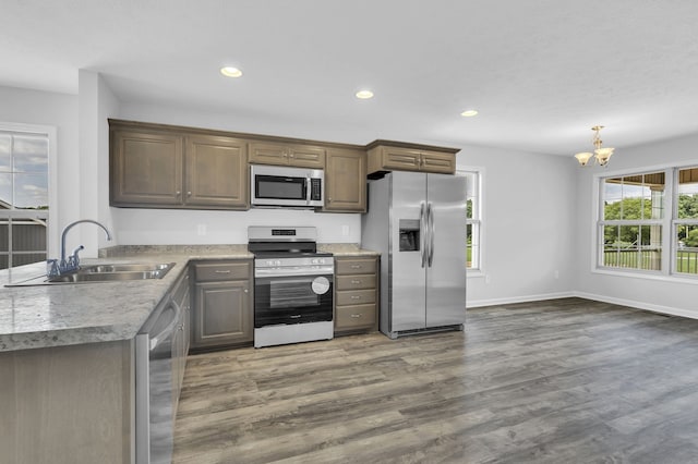 kitchen featuring appliances with stainless steel finishes, sink, a notable chandelier, and hardwood / wood-style flooring