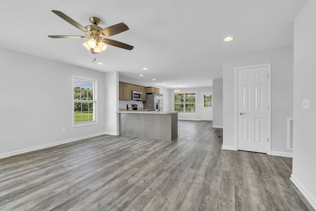 unfurnished living room featuring hardwood / wood-style floors and ceiling fan