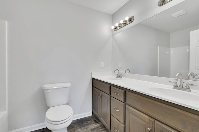 bathroom with vanity, hardwood / wood-style floors, walk in shower, and toilet