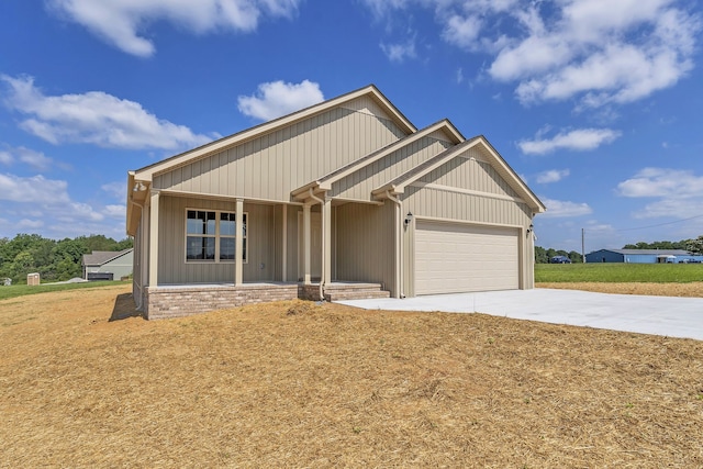 craftsman-style home featuring a garage, a front yard, and covered porch