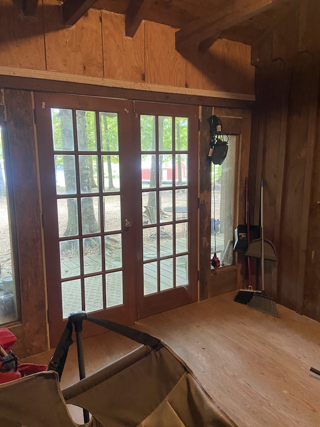 interior space with hardwood / wood-style flooring, wooden walls, and beamed ceiling