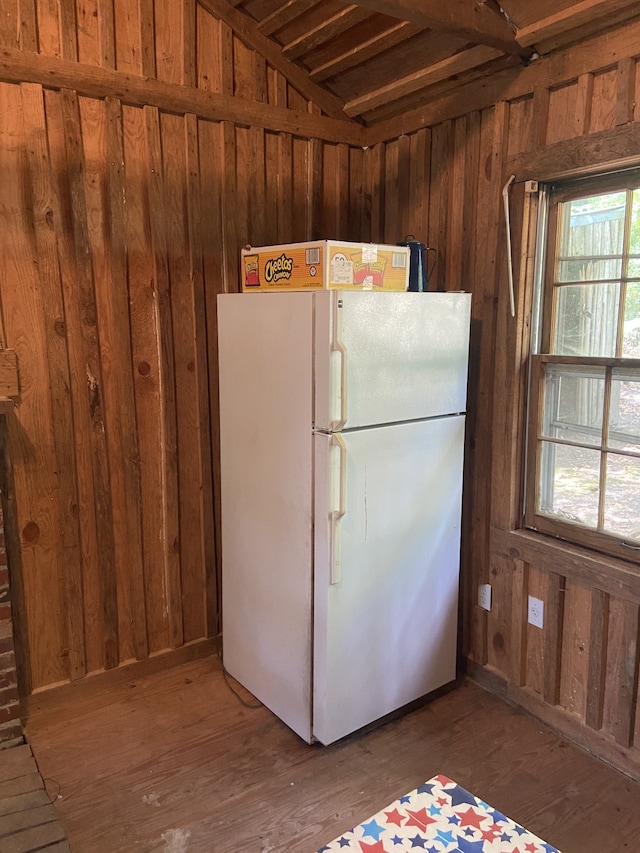 kitchen featuring plenty of natural light, wooden walls, dark hardwood / wood-style flooring, and white refrigerator