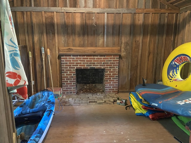 interior space featuring wood-type flooring, wooden walls, and a fireplace