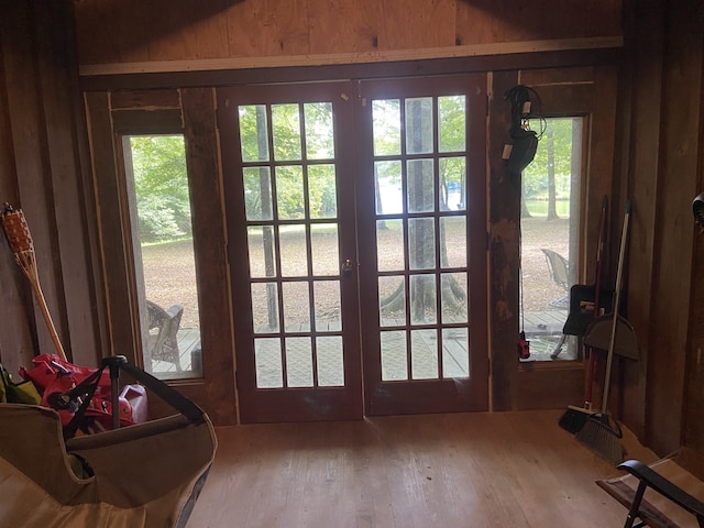 doorway with wood walls, french doors, and hardwood / wood-style floors