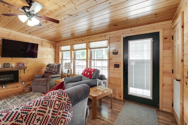 living room with wood-type flooring, plenty of natural light, wooden walls, and wooden ceiling