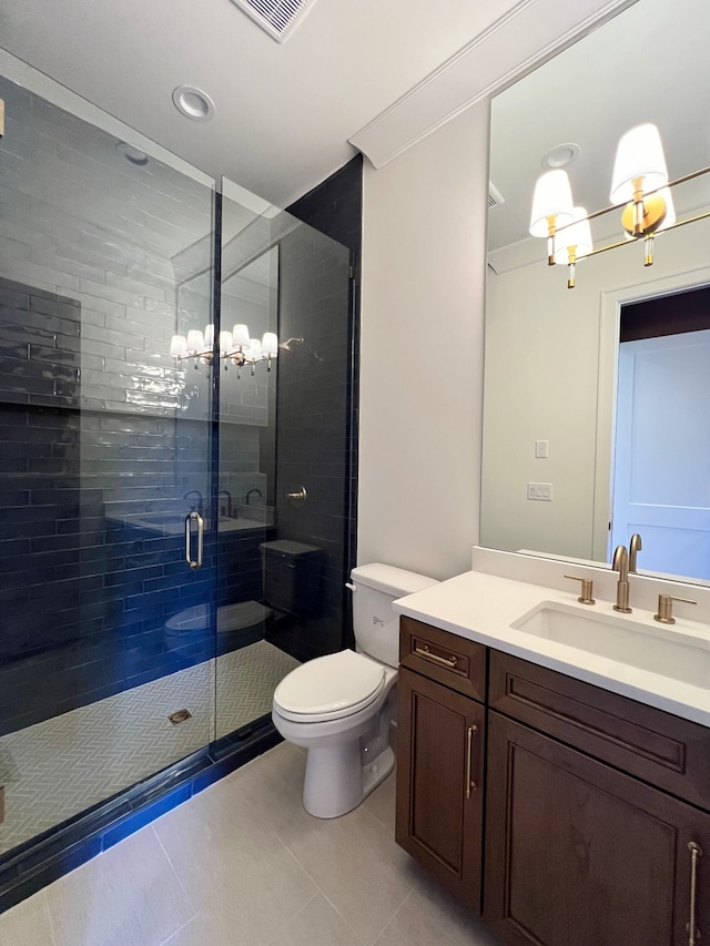 bathroom featuring tile patterned floors, vanity, toilet, and a shower with shower door