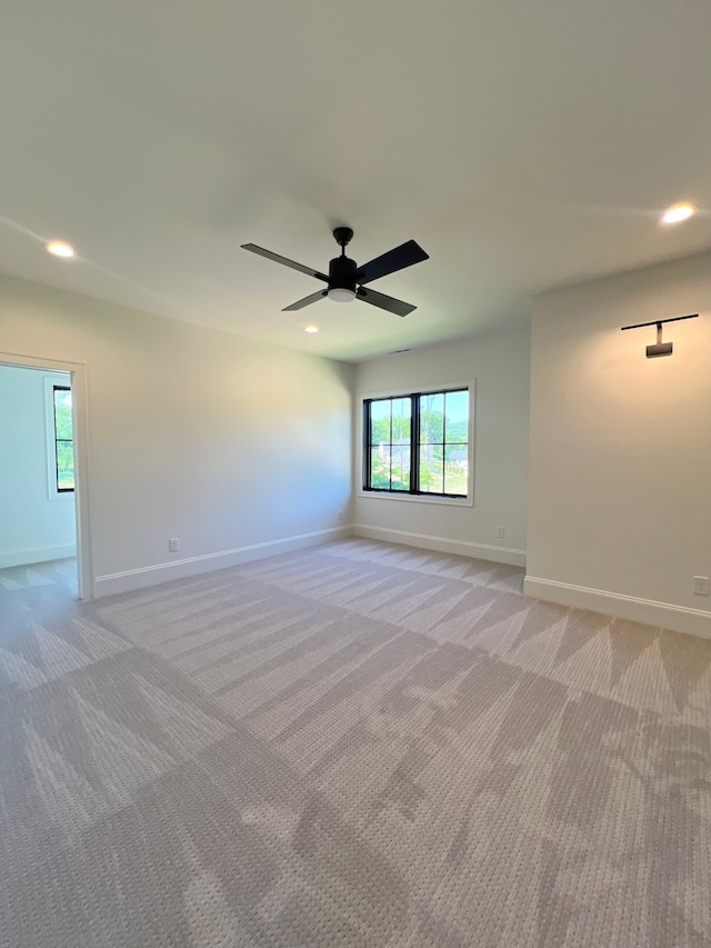 carpeted spare room with ceiling fan