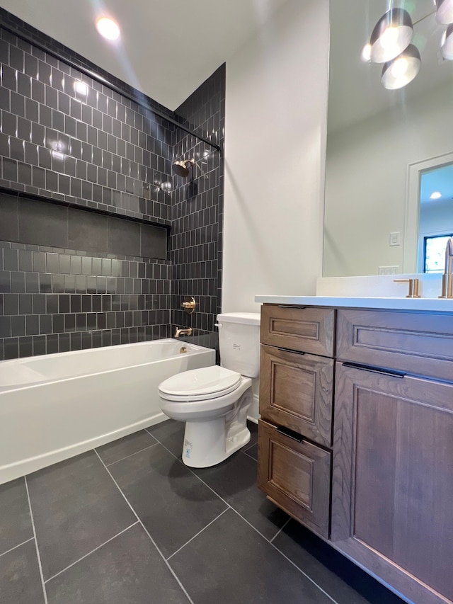 full bathroom featuring vanity, tiled shower / bath combo, tile patterned floors, and toilet