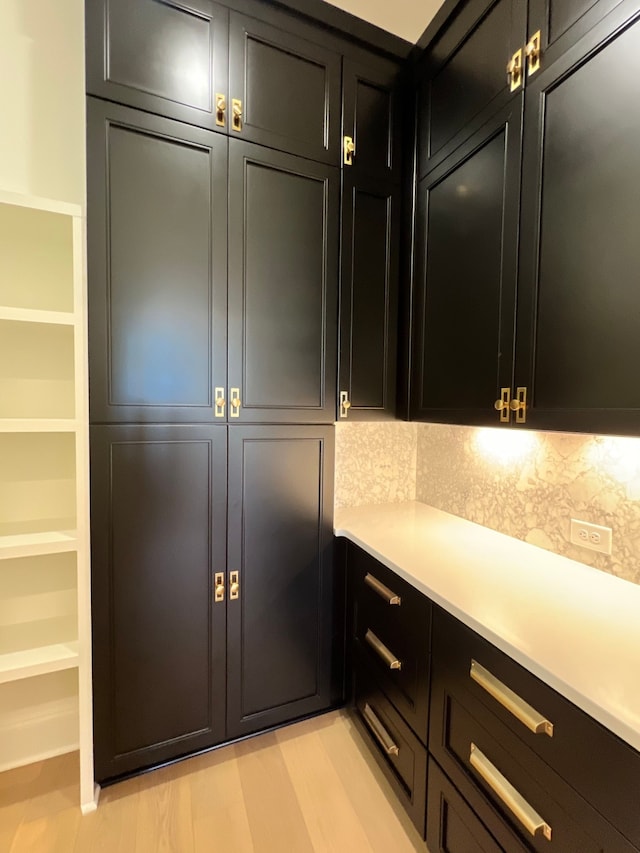 bar featuring decorative backsplash and light hardwood / wood-style floors