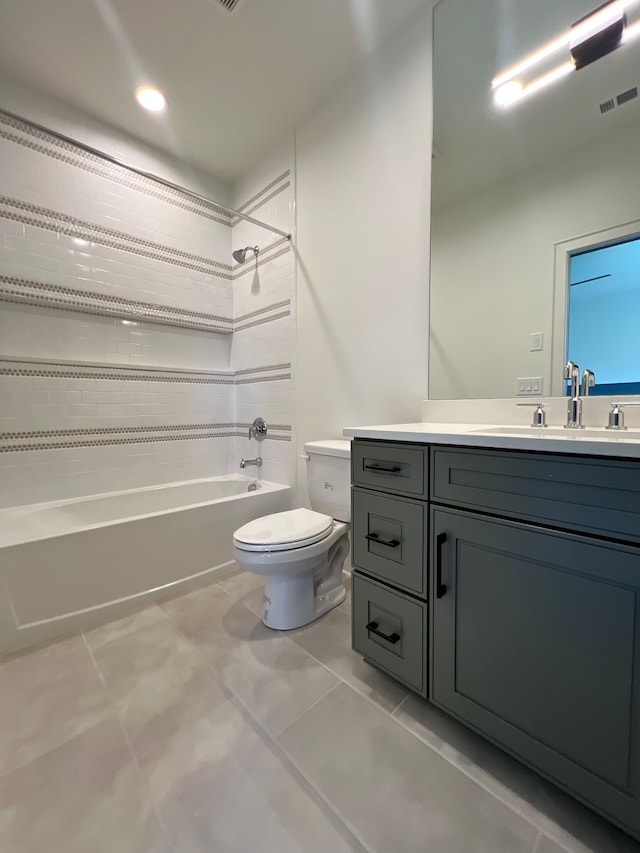 full bathroom featuring tile patterned floors, vanity, toilet, and tiled shower / bath combo