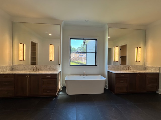 bathroom with ornamental molding, vanity, tile patterned flooring, and a tub