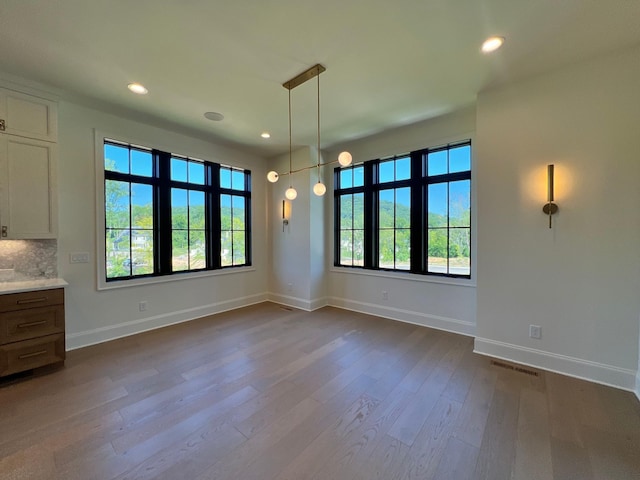 unfurnished dining area featuring visible vents, recessed lighting, baseboards, and dark wood-style flooring