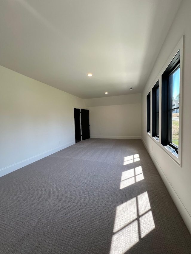 carpeted spare room featuring recessed lighting and baseboards