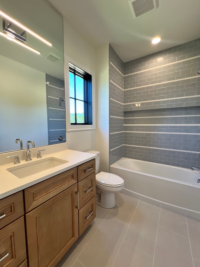 full bathroom featuring vanity, tiled shower / bath, tile patterned floors, and toilet