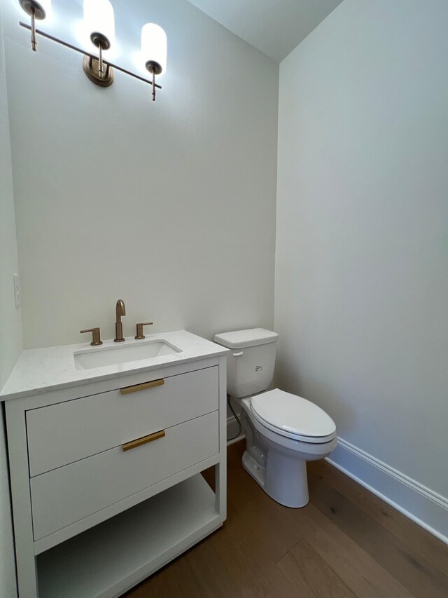 bathroom featuring vanity, hardwood / wood-style floors, and toilet