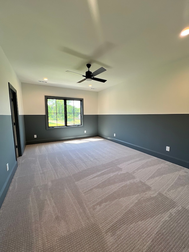 carpeted spare room featuring ceiling fan