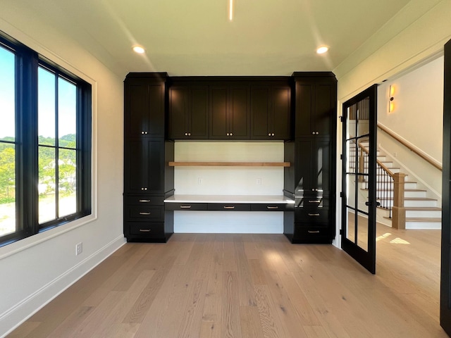 interior space featuring dark cabinetry, light countertops, light wood-style flooring, and recessed lighting