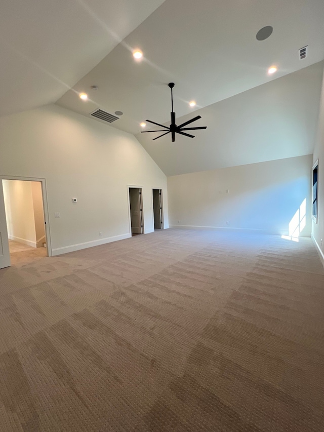 carpeted spare room featuring high vaulted ceiling and ceiling fan