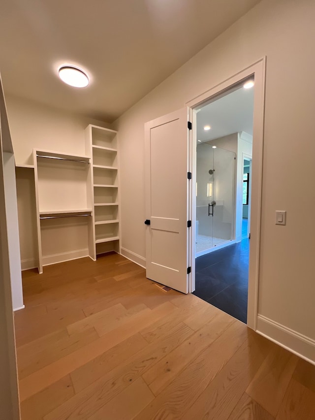 walk in closet with hardwood / wood-style flooring