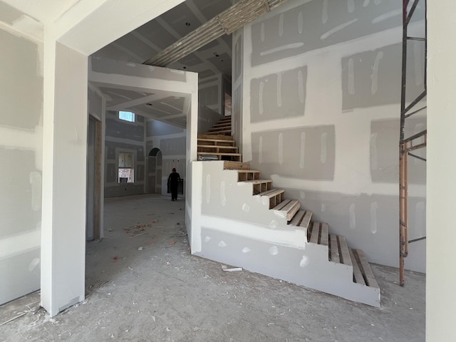 basement featuring stairway and arched walkways