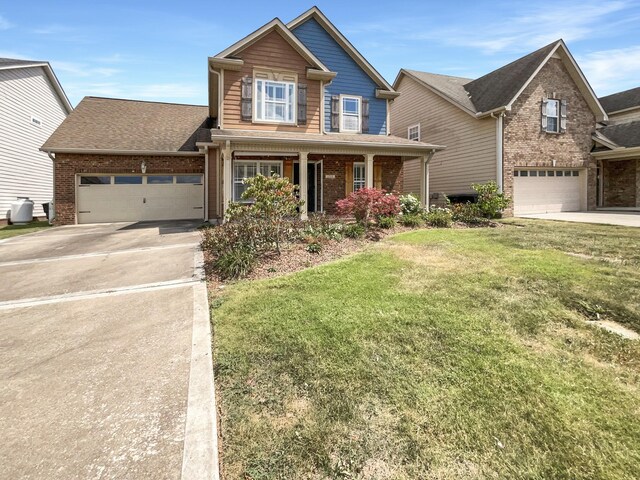 craftsman-style house featuring a garage, a porch, and a front yard