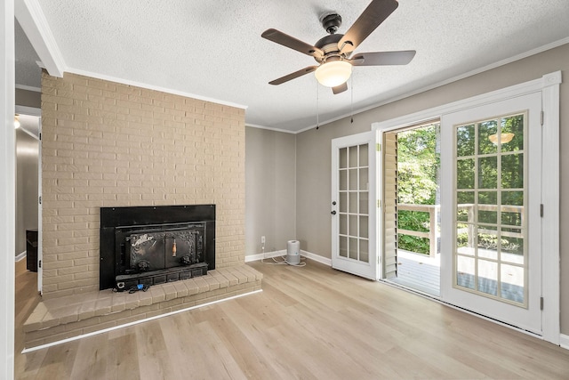 unfurnished living room with ornamental molding, a fireplace, a textured ceiling, and wood finished floors