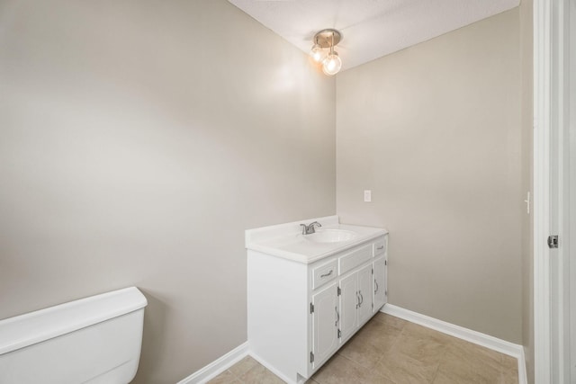 bathroom with vanity, toilet, and baseboards