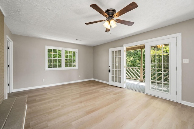 spare room featuring a ceiling fan, a textured ceiling, baseboards, and wood finished floors