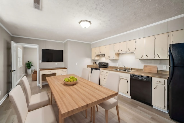 kitchen with light wood-style flooring, ornamental molding, a sink, a textured ceiling, and black appliances