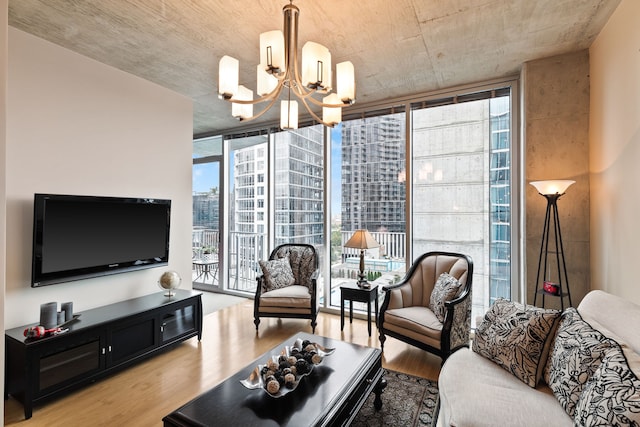 living room with an inviting chandelier, light hardwood / wood-style floors, and a healthy amount of sunlight