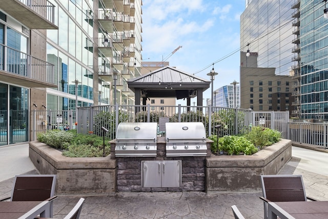 view of patio with grilling area, area for grilling, and a balcony