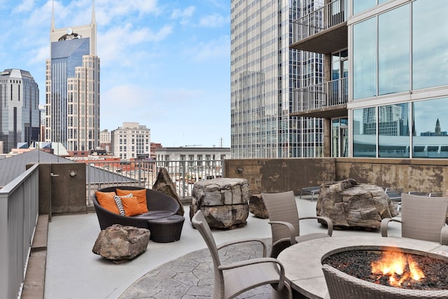 view of patio featuring a fire pit and a balcony