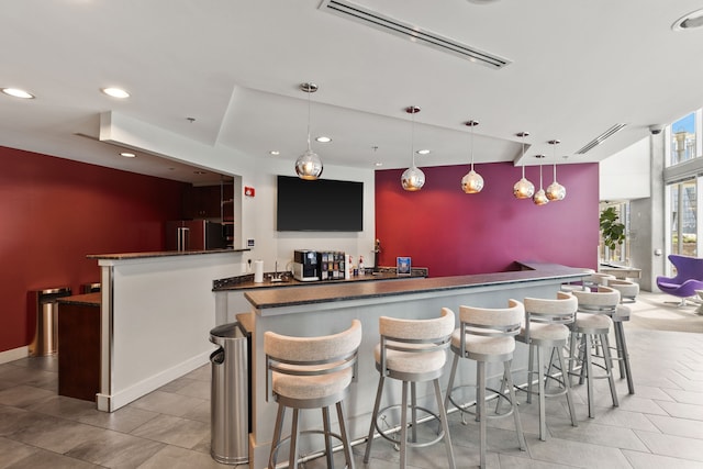 bar featuring high end fridge and hanging light fixtures