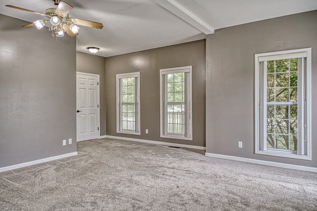 carpeted empty room with beamed ceiling and ceiling fan